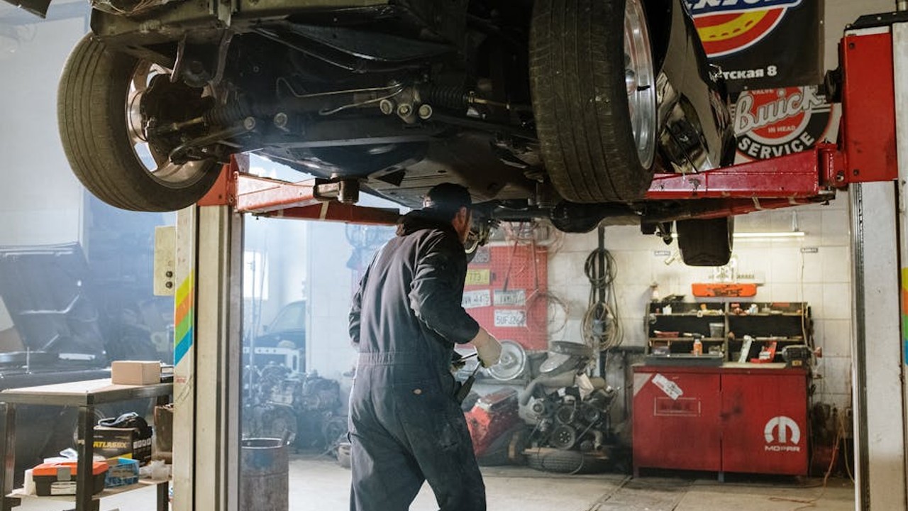 Mobile car diagnostic service technician checking vehicle engine at a ...